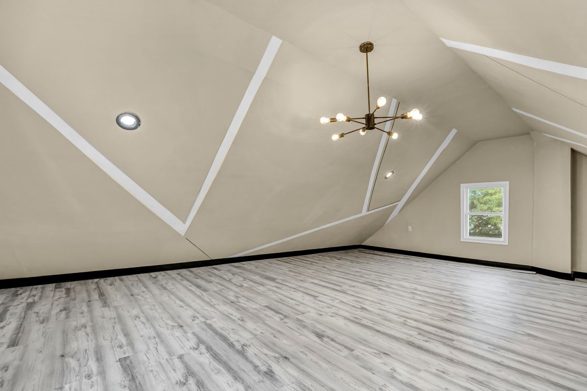 Afgewerkte zolderkamer met schuine wanden en een nieuwe vloer