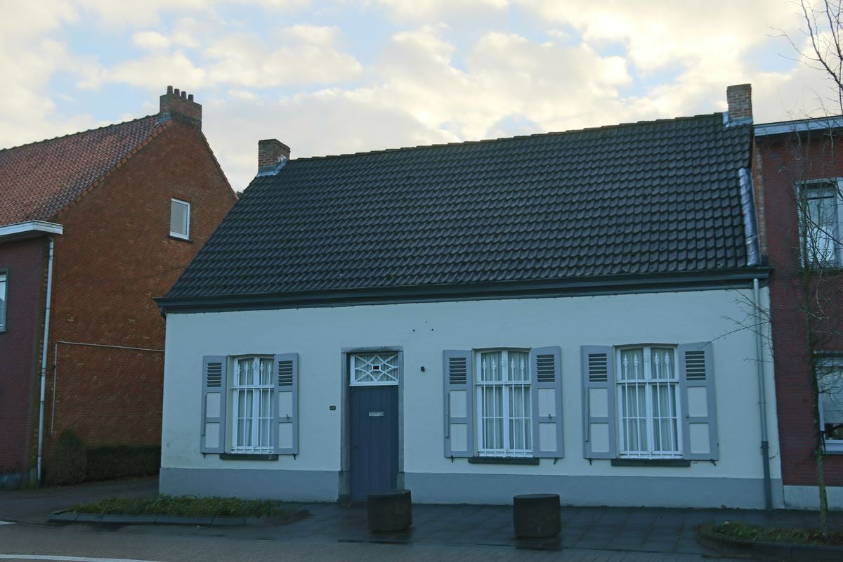 Witte woning met grijze luiken aan het Dorp in Bevel
